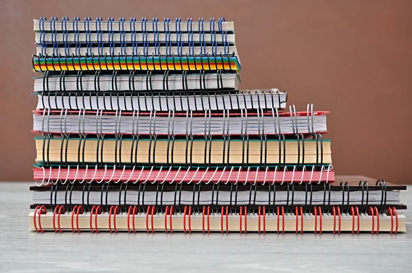 Spiral notebooks stacked on a shelf