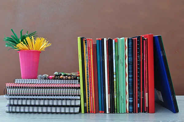 Spiral notebooks stacked on a shelf