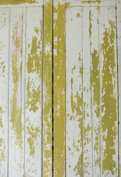 The yellow paint of woods is peeling off wallpaper