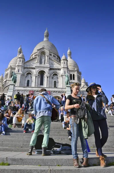 PARIS, FRANCE - 20 APRIL 2015: Tourists visiting the Basilica of the Sacred Heart of Paris, a Roman Catholic church and minor basilica, located at the summit of the butte Montmartre, the highest point of Paris