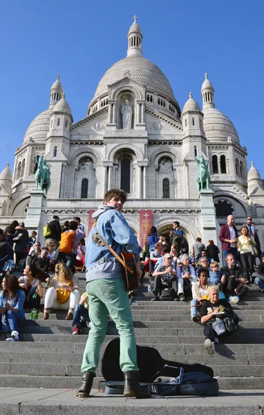 PARIS, FRANCE - 20 APRIL 2015: Tourists visiting the Basilica of the Sacred Heart of Paris, a Roman Catholic church and minor basilica, located at the summit of the butte Montmartre, the highest point of Paris