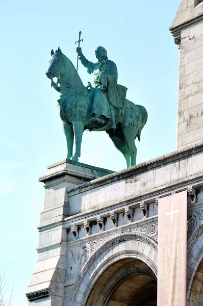 A statue in front of the Basilica of the Sacred Heart of Paris, a Roman Catholic church and minor basilica, located at the summit of the butte Montmartre, the highest point of Paris