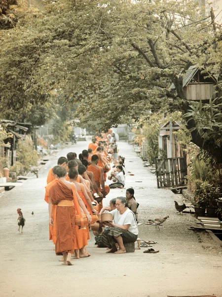 LUANG PRABANG, LAO PDR - June 15, 2004: The old days of alms giving to the monks in Luang Prabang, Lao PDR