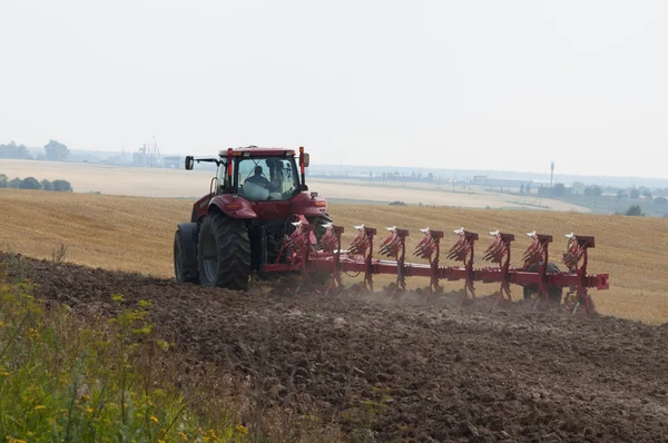 Tractor with plow  on arable land processes