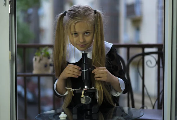 Little girl study with microscope