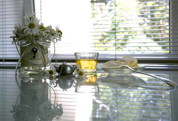 Honey, lemon and a bouquet of daisies on a background of the summer window. Provence