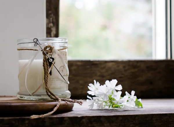 Rustic still life. milk in a glass jar, flowers. vintage, wooden background, window and fresh produce