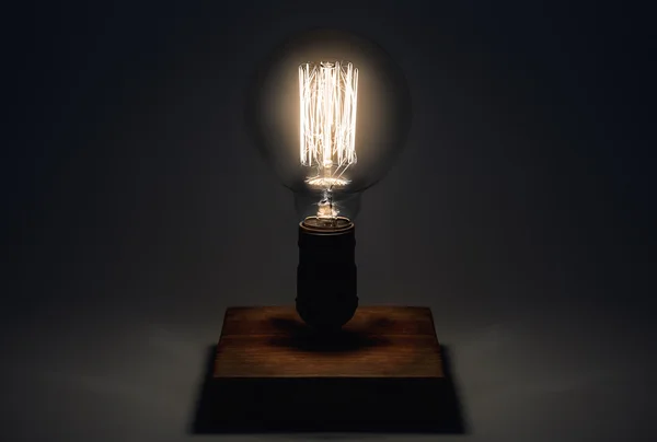 Edison Lamp with filament on a wooden stand. Lighthouse concept