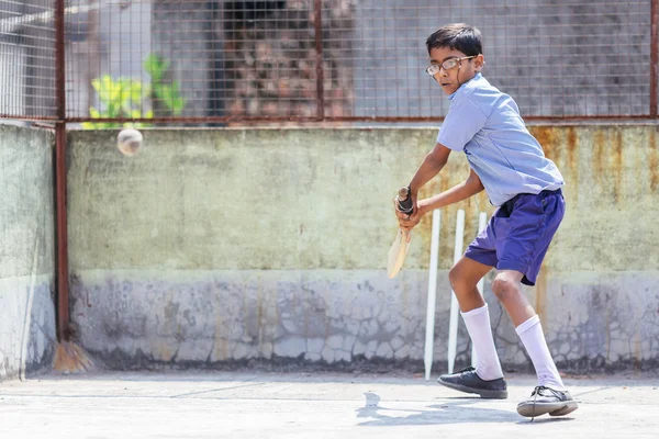 KOLKATA, INDIA - APRIL 14, 2013: Poor indian boy ready to make a beat in the cricket game