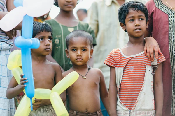 DIAMOND HARBOR, INDIA - MARCH 30, 2013: Poor rural indian children receive balloons from missionaries