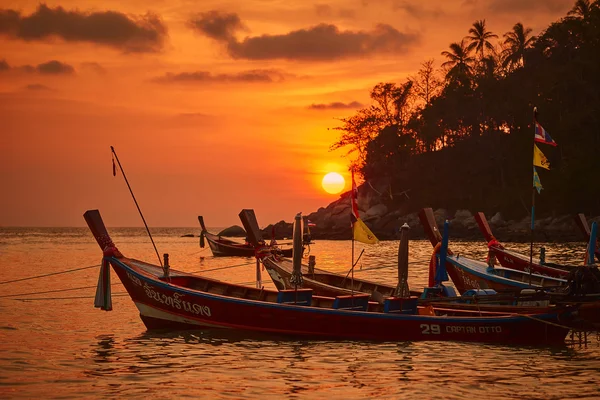 Sunset at Kata beach with fishing boats on the water