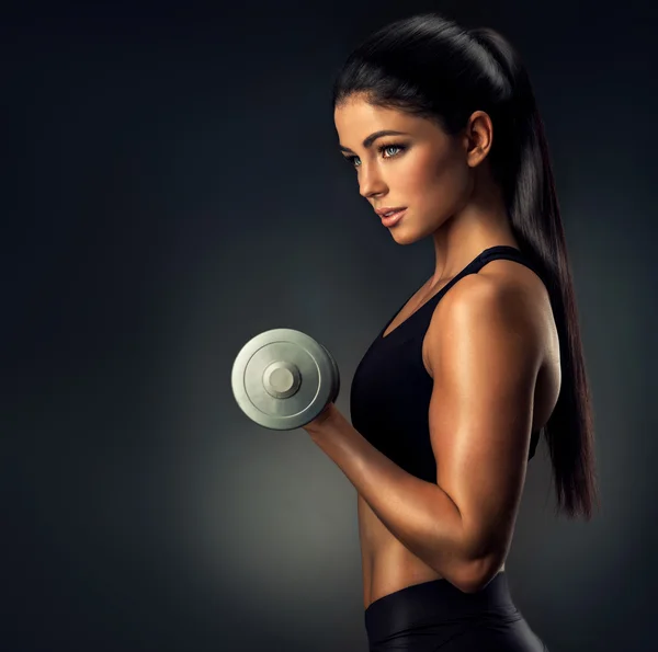 Fitness woman lifting dumbbell