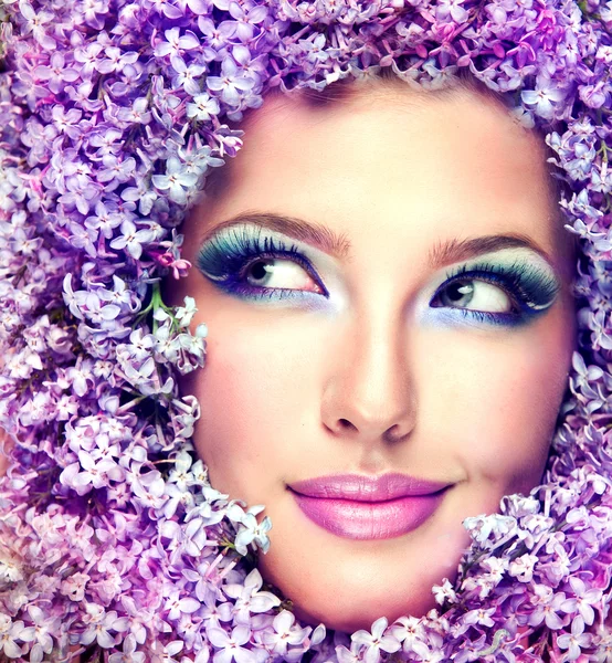 Woman face in lilac flowers