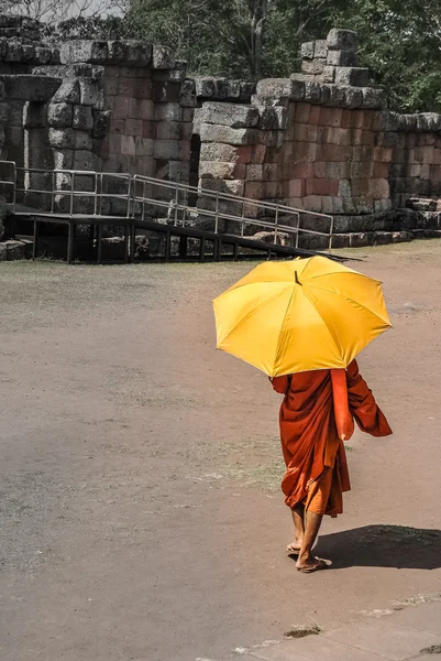 Monk with umbrella walking in the ancient temple. Phanom Rung, Thailand