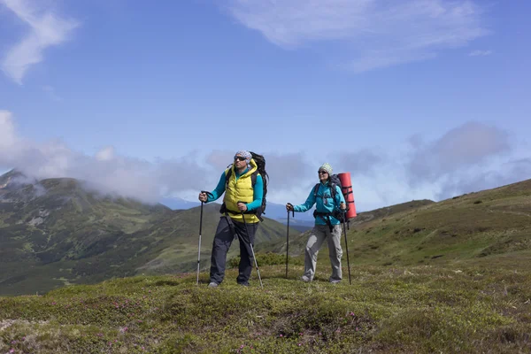 Summer hiking in the mountains with a backpack .