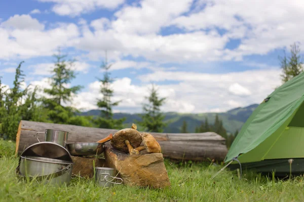 Camping in a mountainous area with cooking equipment.