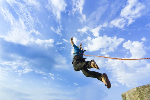 Jump rope from a high rock in the mountains.