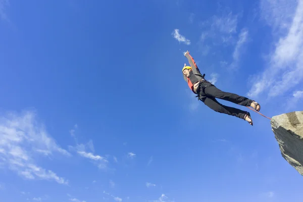 Jump rope from a high rock in the mountains.