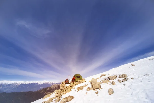 Winter camping in the mountains with a backpack and tent.