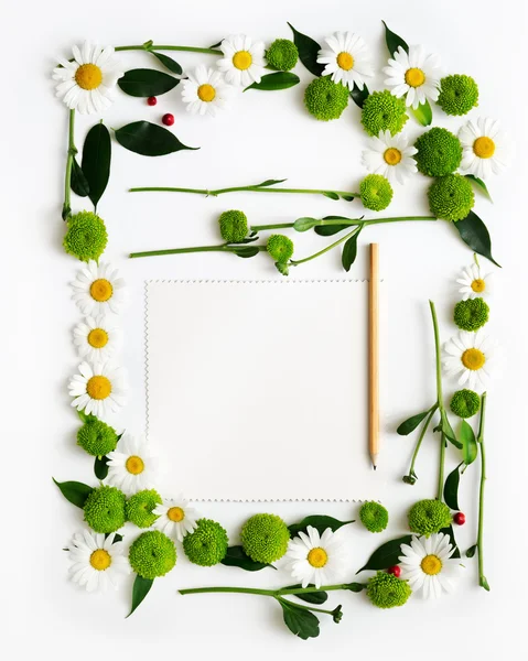 Paper and pencil with wreath frame flowers.