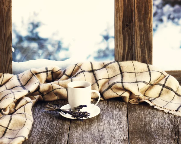 White cup of coffee or tea, lavender flowers and woolen plaid.