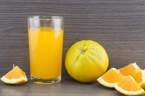 Slices of orange and glass of juice.