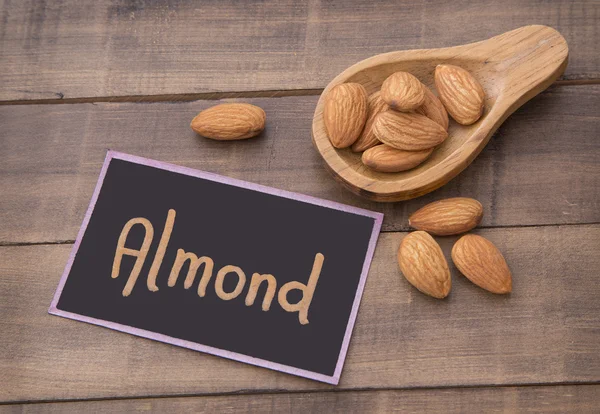 Almonds on the table and wooden spoon