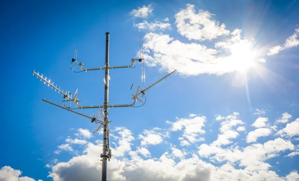 Complex antenna to receive digital TV and radio signals at the antenna mast - a common TV antenna (to receive signals: DVB-T, DVB-T2, DAB, FM from 4 directions, the sun in the frame)