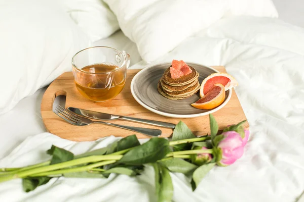 Breakfast in bed, Oatmeal pancakes with grapefruit, tea and Peon