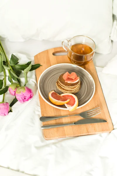 Breakfast in bed, Oatmeal pancakes with grapefruit, tea and Peon