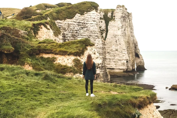 A girl stands on the edge of the cliff