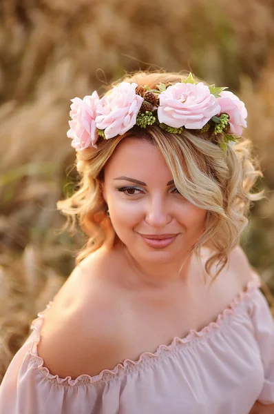 Beautiful girl with pink flowers wreath. Lovely hair and makeup .