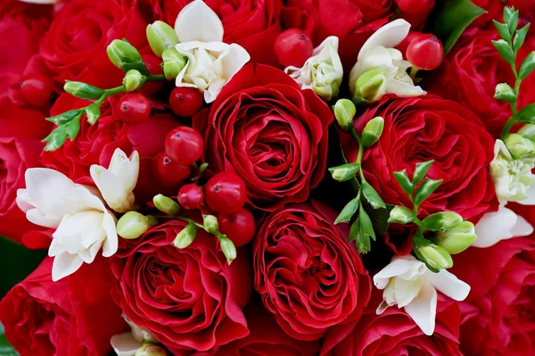 Dense red bouquet of roses, with berries and Close texture