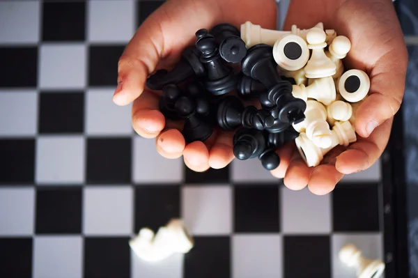 Little baby hands holding the figures of chess.