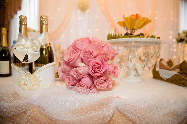 Bouquet of large pink roses on the table newlyweds.