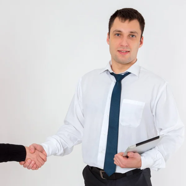 Successful young businessman shaking hands on a light background