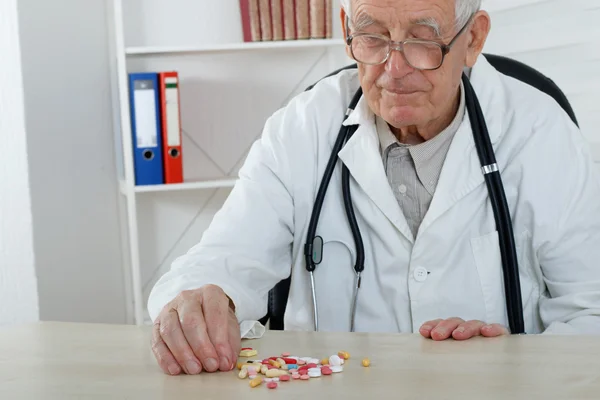 Old doctor with glasses study lot of pills