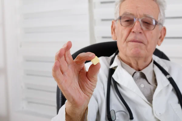 Old doctor observe yellow pill