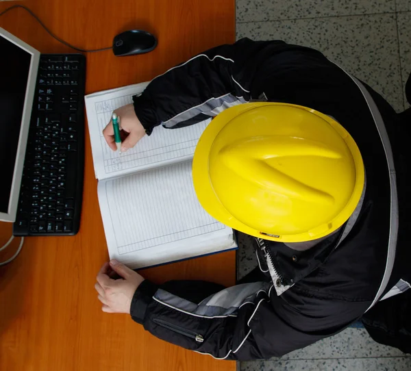 Technician writing data in the power plant control center