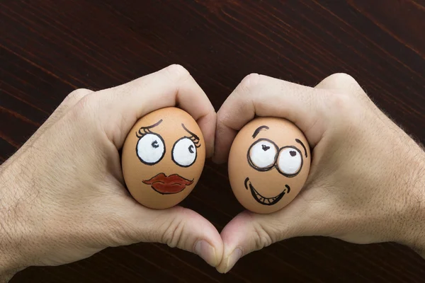 Girl and boy egg face in man hand