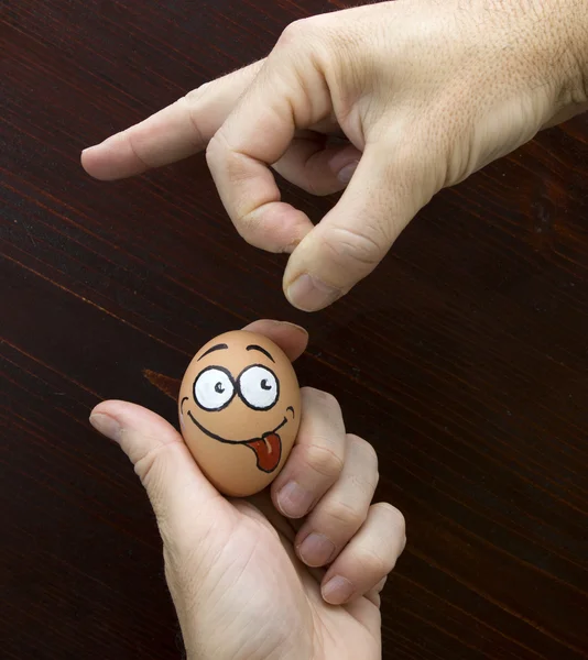 Funny egg face is crawl in man hand