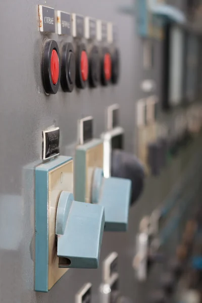 Part of power plant control panel with switches and red buttons