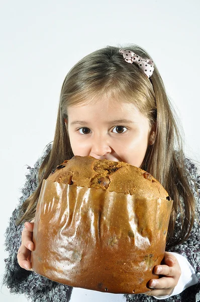 Little girl with panettone at Christmas. Panettone Christmas cake. Litte girl with Italian panetone in Christmas holidays.