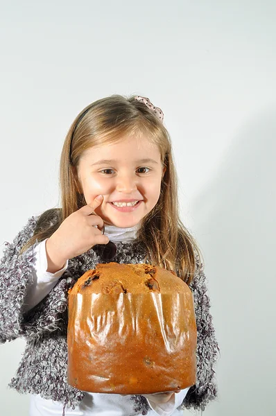 Little girl with panettone at Christmas. Panettone Christmas cake. Litte girl with Italian panetone in Christmas holidays.