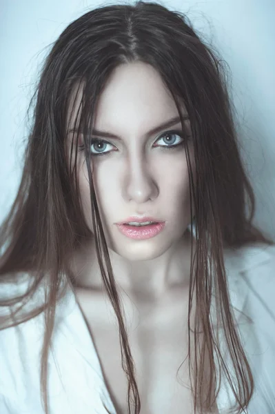 Close-up of beautiful wet woman face with water drop. On green b