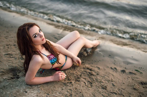 Pretty young woman in bikini posing outdoor in summer on the beach vacation