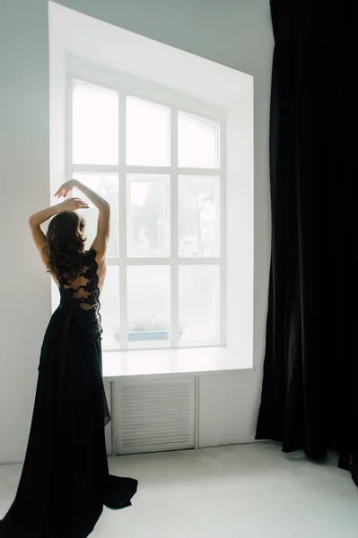 Individuality. Thoughtful Elegant Lady in Black Prom Evening Dress. Studio retouched photo.
