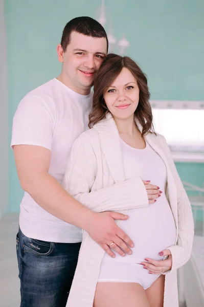 Family waiting for baby\'s birth. A pregnant woman and her husband wearing white clothing