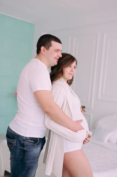 Family waiting for baby\'s birth. A pregnant woman and her husband wearing white clothing