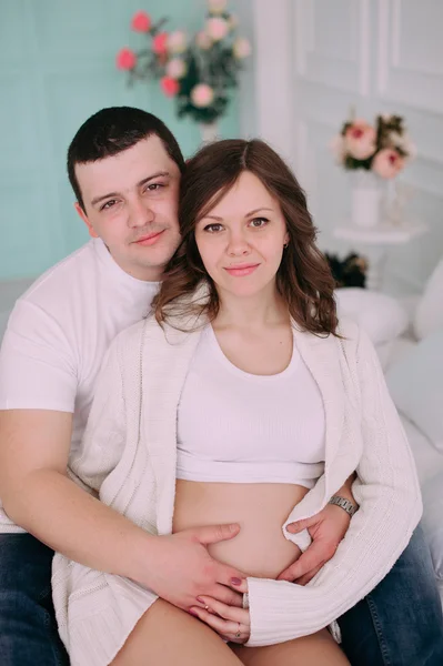 Family waiting for baby\'s birth. A pregnant woman and her husband wearing white clothing